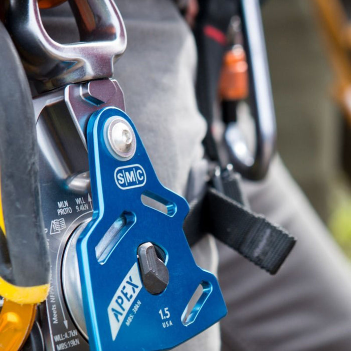 SMC Apex Swivel Pulley attached to a climber’s harness with a carabiner, emphasizing its portability and compatibility with climbing gear.