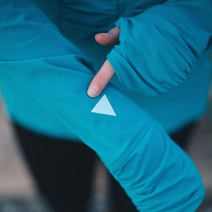 Gear Aid Reflective Tenacious Tape applied to a blue outdoor jacket sleeve in a triangle shape 