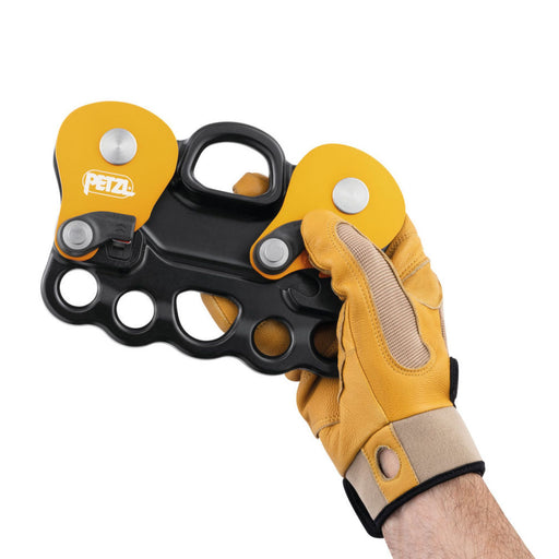 Hand Model Holding a Petzl Reeve Carriage Pulley wearing a glove