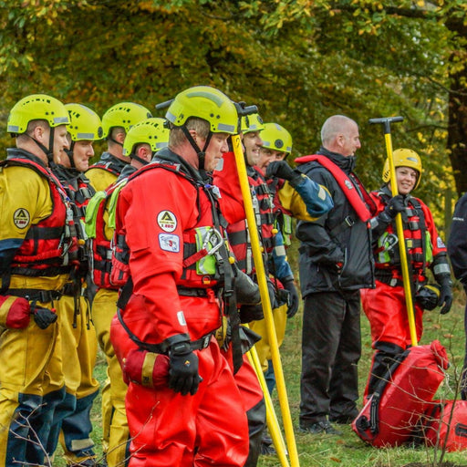 A team of rescue workers in red and yellow suits gathered with their rescue equipment, including the Reach and Rescue Wading Pole, ready for action